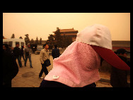 A pedestrian covers her face against the sandstorm on March 20, 2010 in Beijing, China. [Chinanews.com.cn]