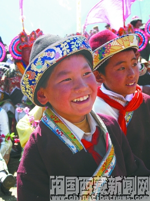 Children watch the show at the opening ceremony of the 8th Nyingchi Peach-Blossom Festival. [Photo Source: chinatibetnews.com]