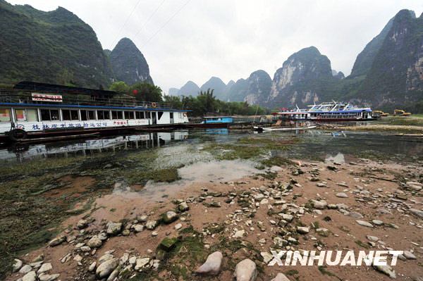 Affected by the severe drought in southwestern China's Guangxi Zhuang Autonomous Region, several reservoirs, including Qing Shitan on the upper reaches of the Li River at Guilin, are reporting water shortages and suspending boat traffic along the river. The tour route along the Li River has been shortened from 60 kilometers to 23 kilometers, forcing some tourist boats to stop operating. [Photo: Xinhua]