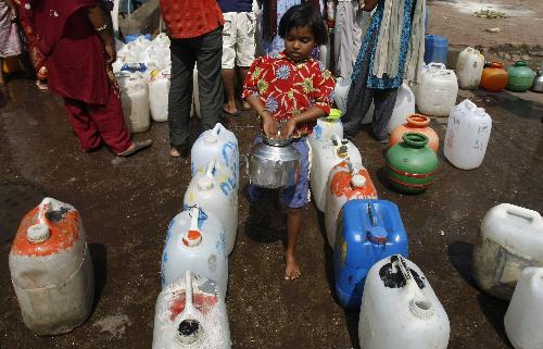A girl carries a pot filled with drinking water at a slum area in India&apos;s financial capital Mumbai March 22, 2010. The Earth is literally covered in water, but more than a billion people lack access to clean water for drinking or sanitation as most water is salty or dirty. March 22 is World Water Day. [Xinhua/Reuters]