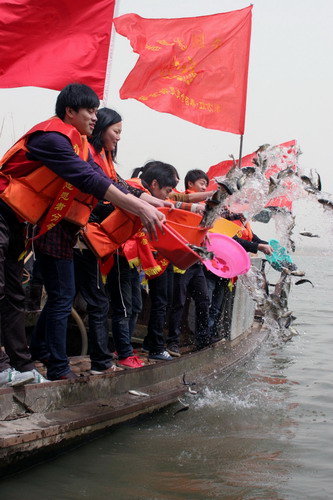 Volunteers free various kinds of fish into Xiazhu lake, a state-level wet-land park in Deqing county, Zhejiang province on March 21, 2010, to mark the 18th World Water Day which falls on March 22. People in different regions of the nation have organized a series of activities to promote water quality.[Xinhua] 