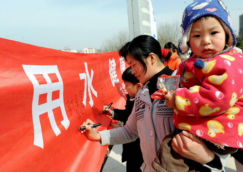 Citizens sign their names on a banner calling for better water sanitation to mark the upcoming World Water Day in Lianyungang, east China&apos;s Jiangsu province on March 21, 2010. [Xinhua]