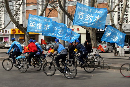 Volunteers ride in the street with banners calling for people to conserve water during a launch ceremony for the coming World Water Day as well as the China Water Week in Handan, north China&apos;s Hebei province on March 21, 2010. [Xinhua]