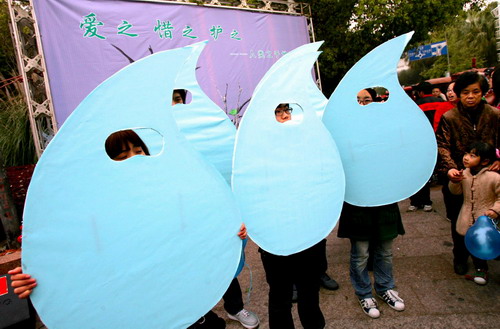 Volunteers dress in costumes as water drops to urge people to cherish the water supply at City Technology College in Wenzhou, east China&apos;s Zhejiang province on March 21, 2010. [Xinhua]