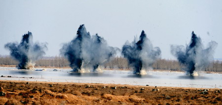 Explosions successfully break the ice of the dangerous Minjibu Reach of the Yellow River under the bombardment in Tumd Right Banner of north China's Inner Mongolia Autonomous Region on March 22, 2010. The 1.5-meter-high ice dam filling up in the riverway was scrapped to meet the extensive ice run.[Xinhua]