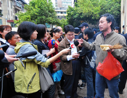 Jounalists interview the parents of the victims of a knife attack, at the gate of the Experimental School, in Nanping City, southeast China's Fujian Province, March 24, 2010. 