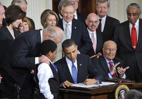 U.S. President Barack Obama (C) signs the healthcare reform bill at the White House in Washington D.C., capital of the United States, March 23, 2010. [Xinhua]
