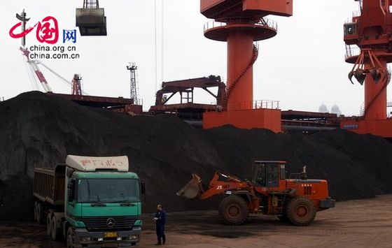 Dock workers are handling the iron ore import from overseas in Qingdao Port. [CFP]