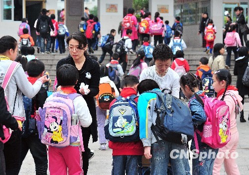 Teachers send out white flowers at the gate of the Experimental School, where a knife attack occurred on Tuesday, in Nanping City, southeast China&apos;s Fujian Province, March 24, 2010. [chinanews.com.cn] 