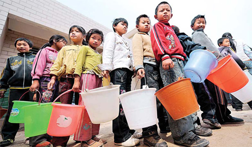 Primary school students wait to collect rationed water in drought-hit Reshui town, Xuanwei, Yunnan province, on Tuesday. [Xinhua]