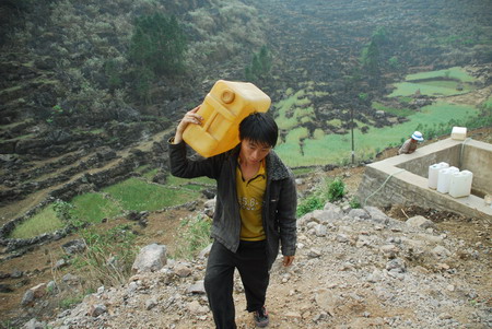 villager carries a bucket of water from a puddle in Luoping county in southwest China&apos;s Yunnan province, on March 24, 2010. The local government and people are struggling against the severe drought, which occurs once in 80 years, and the affected population in Yunnan is expected to reach tens of millions by May this year.[Xinhua]