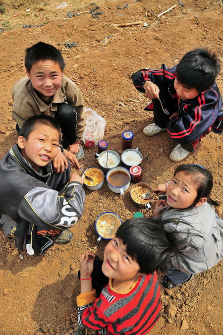 Young students eat lunch in Ganhai village of Xuanwu city, in southwest China&apos;s Yunnan province, on March 24, 2010.[Xinhua]