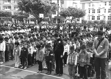 Some 2,000 students and teachers at Nanping Experimental Primary School, Fujian province, stand in silence on Wednesday to mourn the deaths of eight students. [Zhu Xingxin / china daily]