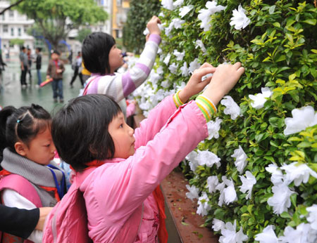 Students decorate a mourning wall with handmade white flowers during a mourning ceremony in the campus, Nanping Experimental Primary School, Nanping of Fujian Province, March24, 2010. [Xinhua] 