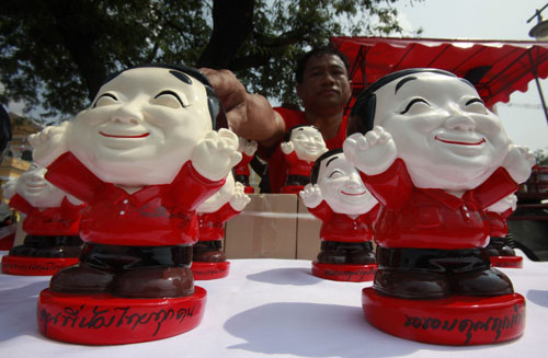 A man sells piggy banks in the shape of former Thai prime minister Thaksin Shinawatra in Bangkok February 2, 2010. [Xinhua/Reuters]