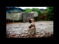 A lone girl is refreshing under the late monsoon rain in the impoverished Oriya Basti Colony in Bhopal, Madhya Pradesh, India, near the former Union Carbide industrial complex, Aug. 25, 2009. When the heavy monsoon rain falls every year, the rain seeps through the buried waste of Union Carbide pollute Bhopal's underground reservoirs. Over 30.000 people are here at risk by the ongoing underground water contamination. [China Daily/CHIPP Organizing Committee] 