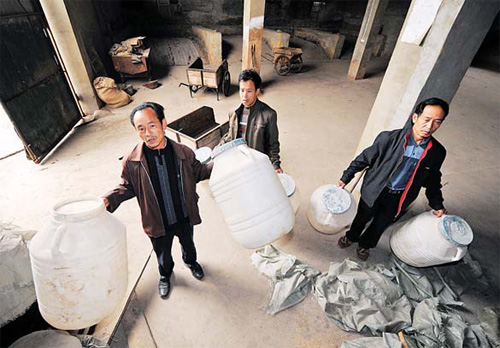 Workers at a liquor workshop near maotai township of Southwest China's Guizhou province show empty water tins, with their business shut down due to a lack of water on Wednesday. [China Daily] 