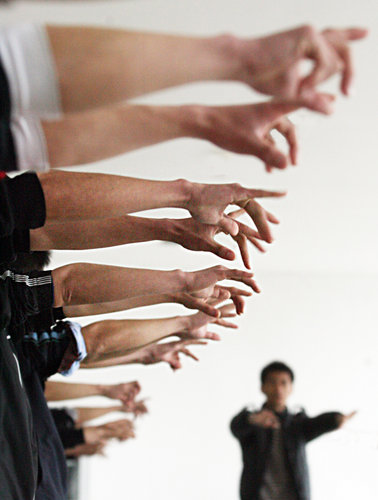 Students from Wuhan Institute of Shipbuilding Technology reach out their hands to receive test of reflexibility at a job fair held by Foxconn quasi-Precision Mold Co Ltd, in Wuhan, Hubei province, on March 23, 2010.