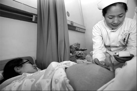 A nurse examines a pregnant woman in a hospital in Xiangfan, Hubei province, on Friday. [Gong Bo/China Daily]