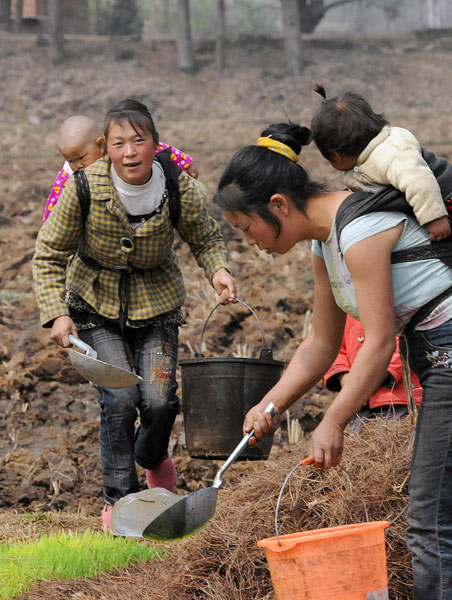 Piggybacking their children, several women water rice plants in a drought-hit village in Yunnan Province, China March 26, 2010.