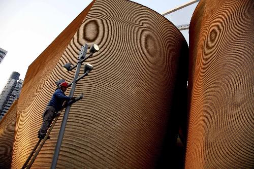A worker checks lighting facilities outside Wanke Pavilion at the Expo Park in Shanghai, east China, March 26, 2010. The Expo Park will be put into trial operation in the end of April.