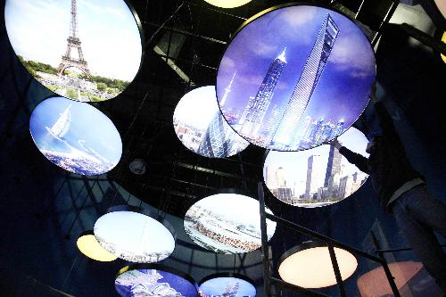 A worker adjusts pictures on shown inside the Oil Pavilion at the Expo Park in Shanghai, east China, March 26, 2010. The Expo Park will be put into trial operation in the end of April.