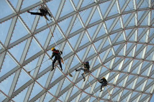 Steeplejacks clean the roof of the Sun Valley at the Expo Axis at the Expo Park in Shanghai, east China, March 26, 2010. The Expo Park will be put into trial operation in the end of April.