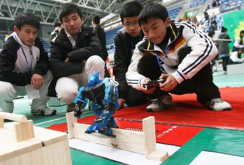 The contestants manipulate their robot, as the 2010 Suzhou Juvenile Robot Contest opens in Suzhou, east China's Jiangsu Province, March 27, 2010. Over 430 students take part in three levels of the contests in elementary school, junior and senior middle school, and categories of basic skills, robot football, robot basketball, etc.