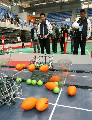 The contestants manipulate their robots in match, as the 2010 Suzhou Juvenile Robot Contest opens in Suzhou, east China's Jiangsu Province, March 27, 2010. Over 430 students take part in three levels of the contests in elementary school, junior and senior middle school, and categories of basic skills, robot football, robot basketball, etc.