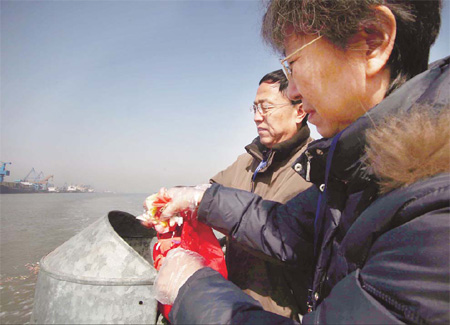 Beijing residents spread flowers during a sea burial in Tianjin on Friday. Wang Jing / China Daily  