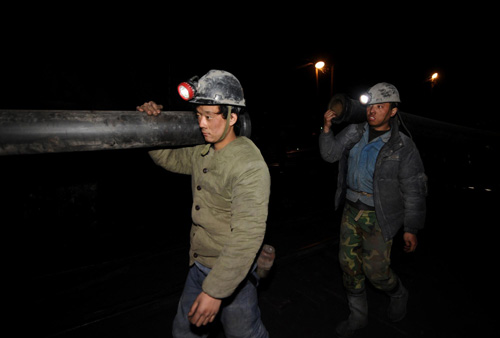 Rescuers carry a pipe during preparations to rescue the trapped coal miners in Shanxi on March 29, 2010. [Xinhua] 