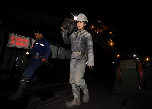 Rescuers carry a pipe during preparations to rescue the trapped coal miners in Shanxi on March 29, 2010. [Xinhua]