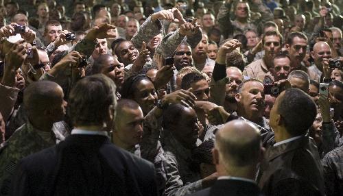 U.S. President Barack Obama (R) visits with troops at Bagram Air Base, March 28, 2010. Obama paid a surprise visit to Afghanistan Sunday, his first as commander-in-chief, to assess his surge of 30,000 troops designed to end the bloody eight-year-old war on the Taliban. [Xinhua]