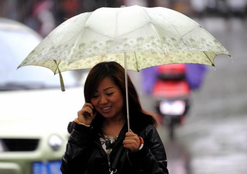 A woman holds an umbrella as she walks in the rain in Kunming, capital of southwest China&apos;s Yunnan Province, March 28, 2010. The rainfall brought some relief to parched Yunnan Province on Sunday as a severe drought ravages southwest China. [Xinhua]