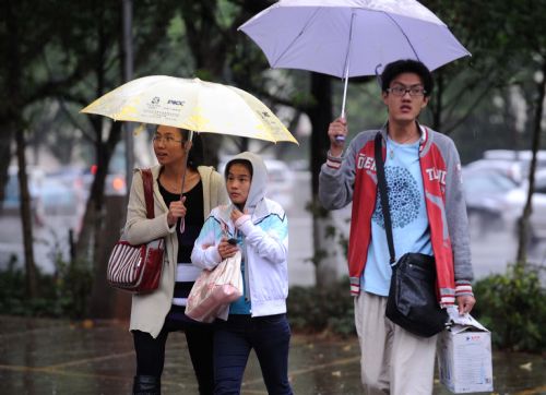 People hold umbrellas as they walk in the rain in Kunming, capital of southwest China's Yunnan Province, March 28, 2010. The rainfall brought some relief to parched Yunnan Province on Sunday as a severe drought ravages southwest China.[Xinhua]