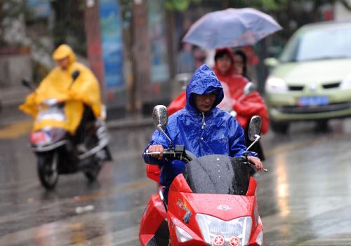 People ride motorcycles in the rain in Kunming, capital of southwest China's Yunnan Province, March 28, 2010. The rainfall brought some relief to parched Yunnan Province on Sunday as a severe drought ravages southwest China.[Xinhua]