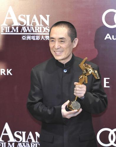 Director Zhang Yimou poses with his trophy after winning the 'Outstanding Contribution to Asian Cinema' award at the Asian Film Awards in Hong Kong, south China, on March 22, 2010. [Xinhua]