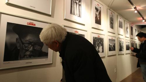 A visitor take a close look at picture displayed at the 'China's Renowned Photographers Focus on China' photo exhibition held in New York, the United States, March 28, 2010.