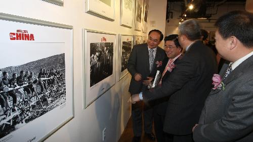 Visitors look at picture displayed at the 'China's Renowned Photographers Focus on China' photo exhibition held in New York, the United States, March 28, 2010.