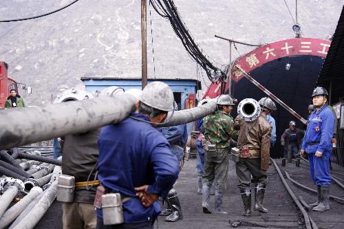 Rescuers carry pipes at the site of a flooding accident of Wangjialing Coal Mine, sitting astride Xiangning County of Linfen City and Hejin City of Yuncheng City, in north China's Shanxi Province, on March 29, 2010. (Xinhua/G