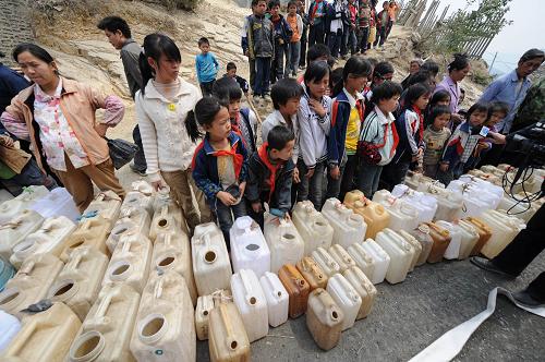 Children queue for water at Nasha Primary School in Sanbao Township of Tian&apos;e County, southwest China&apos;s Guangxi Zhuang Autonomous Region, March 29, 2010. Firemen from Laibin city of Guangxi headed for Tian&apos;e County to provide drinking water for nearly 4,000 drought-affected pupils on Monday. [Xinhua] 