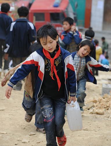 Pupils carry water back to dormitories at Nasha Primary School in Sanbao Township of Tian&apos;e County, southwest China&apos;s Guangxi Zhuang Autonomous Region, March 29, 2010. [Xinhua]