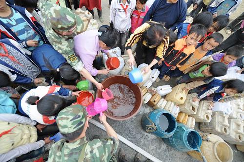 Children queue for water at Nasha Primary School in Sanbao Township of Tian&apos;e County, southwest China&apos;s Guangxi Zhuang Autonomous Region, March 29, 2010. [Xinhua]