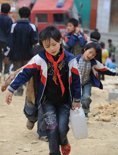 Pupils carry water back to dormitories at Nasha Primary School in Sanbao Township of Tian&apos;e County, southwest China&apos;s Guangxi Zhuang Autonomous Region, March 29, 2010.[Xinhua]
