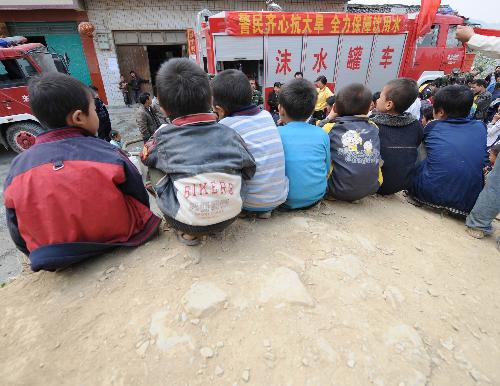 Children queue for water at Nasha Primary School in Sanbao Township of Tian'e County, southwest China's Guangxi Zhuang Autonomous Region, March 29, 2010. [Xinhua]