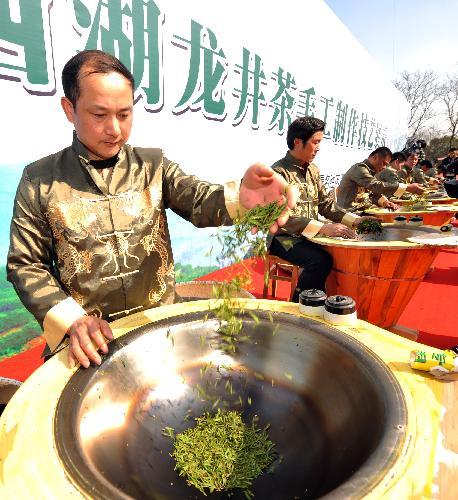 People perform tea frying skills during the opening ceremony of the West Lake International Tea Culture Expo held in Hangzhou, east China's Zhejiang Province, March 26, 2010. The expo will last till April 23, 2010. [Xinhua photo]