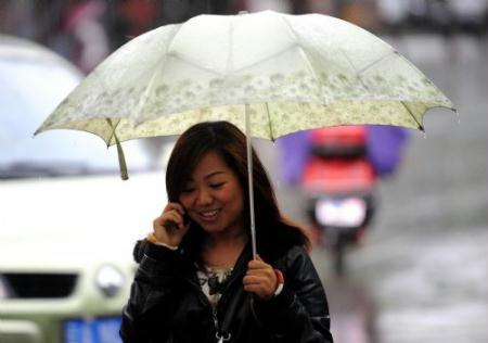 A woman holds an umbrella as she walks in the rain in Kunming, capital of southwest China&apos;s Yunnan Province, March 28, 2010. The rainfall brought some relief to parched Yunnan Province on Sunday as a severe drought ravages southwest China.