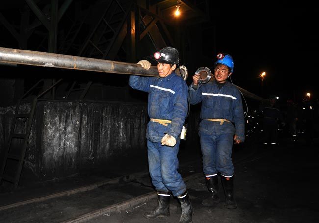 Rescuers carry pipes at the site of a flooding accident of Wangjialing Coal Mine, sitting astride Xiangning County of Linfen City and Hejin City of Yuncheng City, in north China&apos;s Shanxi Province, on March 29, 2010. [Xinhua]