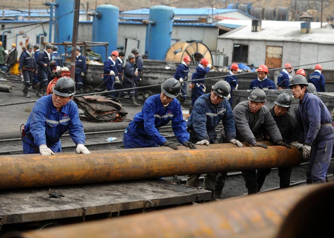 Rescuers carry pipes at the site of a flooding accident of Wangjialing Coal Mine, sitting astride Xiangning County of Linfen City and Hejin City of Yuncheng City, in north China&apos;s Shanxi Province, on March 29, 2010. [Xinhua]