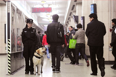  Police patrols aided with sniffer dogs are seen at Beijing&apos;s metro stations on March 30, 2010. [Xinhua]